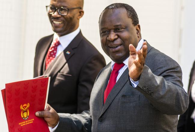 © Bloomberg. Tito Mboweni, South Africa's finance minister, gestures as he heads to parliament to present his mid-term budget in Cape Town, South Africa. 