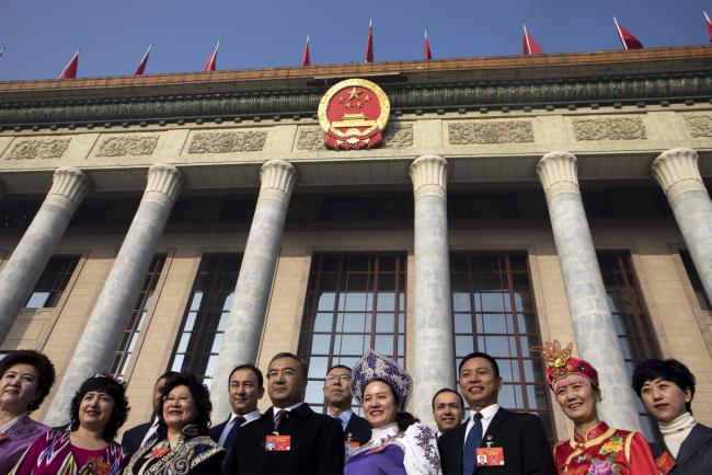 © Bloomberg. Delegates pose for photographs in front of the Great Hall of the People in Beijing. Photographer: Giulia Marchi/Bloomberg