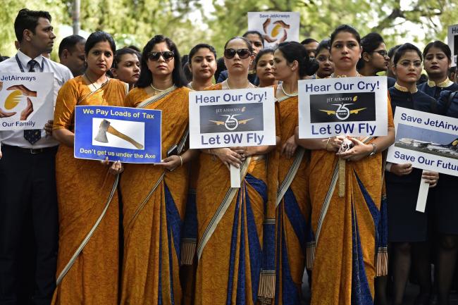 © Bloomberg. Cabin crew hold placards during a protest on April 18. Photographer: Anindito Mukherjee/Bloomberg