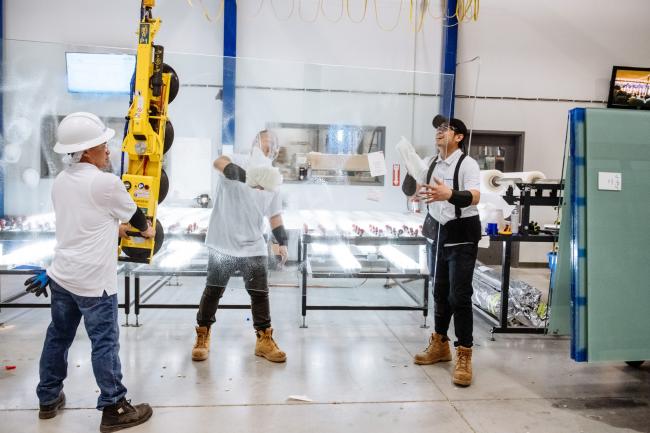 © Bloomberg. Workers wipe down glass at the lamination station inside the iMagic Glass Inc. factory in Vaughan, Ontario, Canada, on Tuesday, Feb. 19, 2019. iMagic Glass is riding a wave of demand for ever more elaborate stores from luxury retailers trying to persuade consumers to forsake online shopping for a luxurious brick-and-mortar experience. Photographer: Galit Rodan/Bloomberg