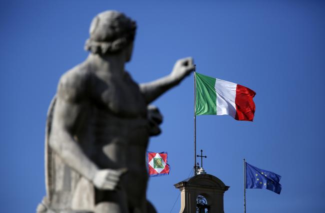 © Bloomberg. The national flag of Italy, center, and the European Union (EU) flag, right, fly from the Quirinale palace, the office of Italy's president, in Rome, Italy, on Friday, Feb. 21, 2014.  Photographer: Alessia Pierdomenico/Bloomberg