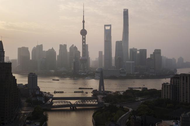 © Bloomberg. The Oriental Pearl Tower, center left, Shanghai World Financial Center, center, and the Shanghai Tower, center right, stand among other buildings in the Lujiazui Financial District along the Pudong riverside in this aerial photograph taken above Shanghai, China, on Monday, April 2, 2018. China's sprawling local government financing system needs 