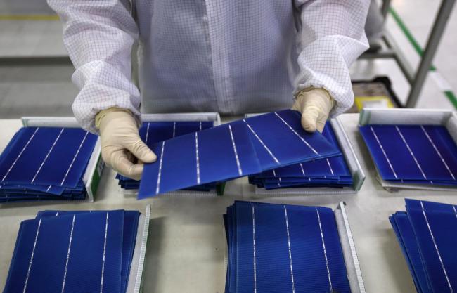 © Bloomberg. An employee performs a final inspection on solar cells on the production line at the Trina Solar Ltd. factory in Changzhou, Jiangsu Province, China, on Friday, April 24, 2015. Photographer: Tomohiro Ohsumi/ 