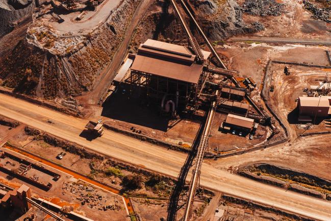 © Bloomberg. A dumper truck drives by a conveyor belt at the Sishen open cast mine, operated by Kumba Iron Ore Ltd., an iron ore-producing unit of Anglo American Plc, in Sishen, South Africa, on Tuesday, May 22, 2018. Kumba Iron Ore may diversify into other minerals such as manganese and coal as Africa’s top miner of the raw material seeks opportunities for growth and to shield its business from price swings. Photographer: Waldo Swiegers/Bloomberg