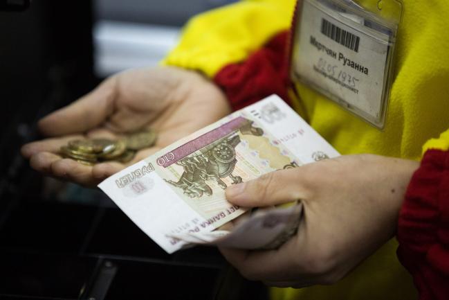 © Bloomberg. A cashier handles ruble banknotes and coins inside a Magnit PJSC hypermarket store at the Hanoi-Moscow trade centre in Moscow, Russia, on Wednesday, Feb. 28, 2018.