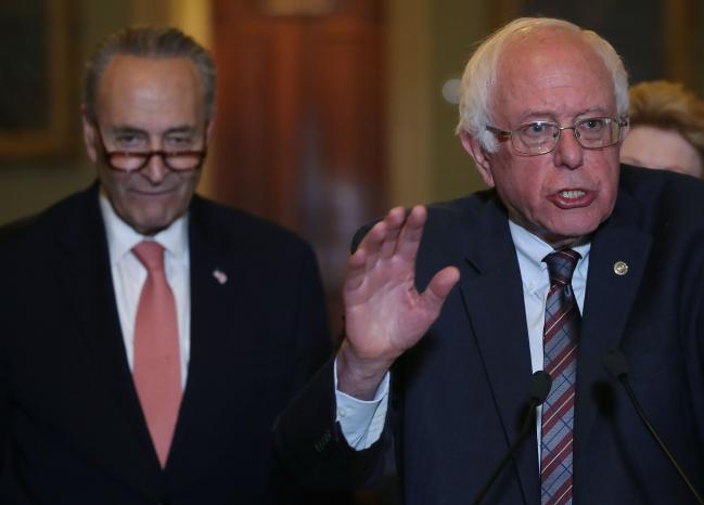 © Bloomberg. WASHINGTON, DC - MAY 23: Sen. Bernie Sanders (I-VT) (R), is flanked by Senate Minority Leader Charles Schumer (D-NY) while speaking to the media about President Trump's Proposed FY 2018 budget, on Capitol Hill on May 23, 2017 in Washington, DC. (Photo by Mark Wilson/Getty Images)