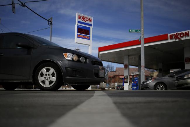 © Bloomberg. Gas prices are displayed as cars drive past an Exxon Mobil Corp. station in Cincinnati, Ohio, U.S. on Monday, Jan. 27, 2014. Exxon Mobil Corp. is scheduled to release their fourth quarter earnings on Thursday, Jan. 30, 2014. Exxon Mobil Corp. is scheduled to release earnings figures on Jan. 30. Photograper: Luke Sharrett/Bloomberg