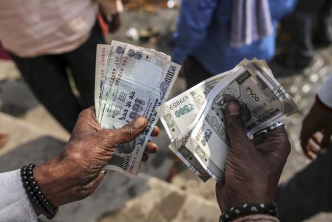 © Bloomberg. A man counts Indian rupee banknotes in an arranged photograph in Varanasi, Uttar Pradesh, India, on Saturday, Oct. 29, 2017. A big drop in borrowing costs for Indian state lenders on perpetual bond offerings shows that the government’s surprise $32 billion capital pledge last week has finally managed to turn around market sentiment.