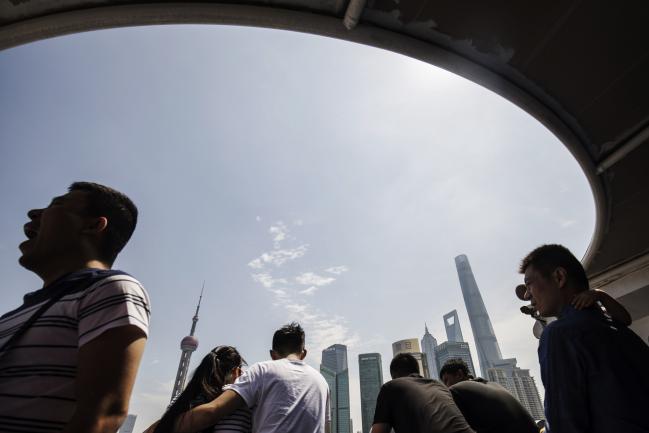 © Bloomberg. Tourists ride on a ferry crossing the Huangpu River as buildings stand in Pudong's Lujiazui financial district in Shanghai, China, on Saturday, June 2, 2018. China's banks, scrambling to adjust to the government's deleveraging campaign, are likely to add to pressures on the corporate bond market as they shed more of their massive note holdings and de-risk their balance sheets. 
