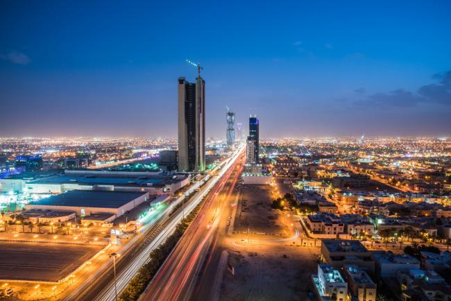 © Bloomberg. Light trails from traffic illuminate highways surrounded by residential buildings in Riyadh, Saudi Arabia.