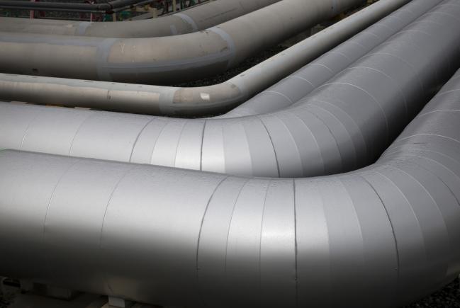 © Bloomberg. Gas pipes sit near a liquefied natural gas (LNG) storage tank under construction at Tokyo Electric Power Co.'s (Tepco) Futtsu gas-fired thermal power plant in Futtsu, Chiba Prefecture, Japan, on Monday, Sept. 10, 2018. Japan will maintain a target for clean energy to account for as much as 24 percent of the countrys power mix by 2030, according to a long-term plan approved by the Cabinet in July. 