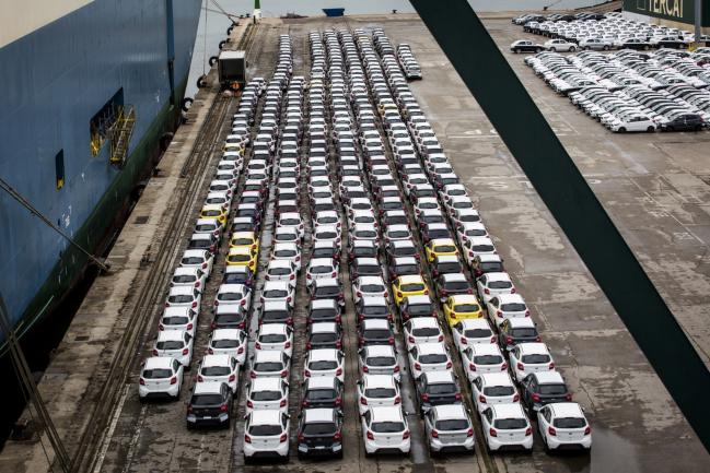 &copy Bloomberg. Newly manufactured imported automobiles sit on the dockside in the Auto Terminal SA parking lot at the port of Barcelona. Photographer: Angel Garcia/Bloomberg