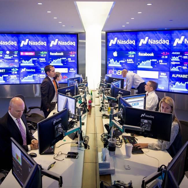 © Bloomberg. Analysts monitor data at the Market Intelligence Desk (MID) inside the Nasdaq MarketSite in New York, U.S., on Thursday, Aug. 18, 2016. U.S. stocks fluctuated as investors weighed near-record equity levels, and indications an uncertain economic outlook leaves policy makers with little reason to raise interest rates.