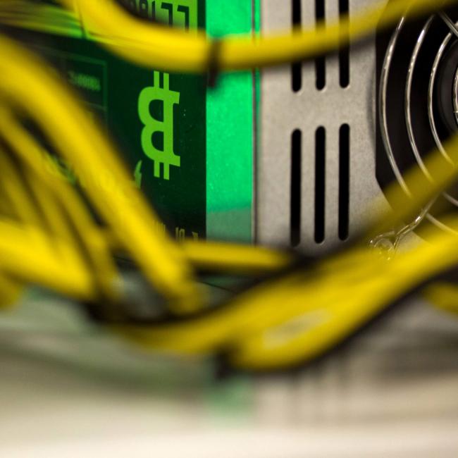 © Bloomberg. A bitcoin logo sits on a LL 1800W power unit supplying cryptocurrency mining machines at the SberBit mining \\'hotel\\' in Moscow, Russia, on Saturday, Dec. 9, 2017. Futures on the world’s most popular cryptocurrency surged as much as 26 percent in their debut session on Cboe Global Markets Inc.\\'s exchange, triggering two temporary trading halts designed to calm the market.