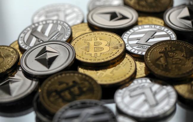 © Bloomberg. A collection of bitcoin, litecoin and ethereum tokens sit in this arranged photograph in Danbury, U.K., on Tuesday, Oct. 17, 2017.