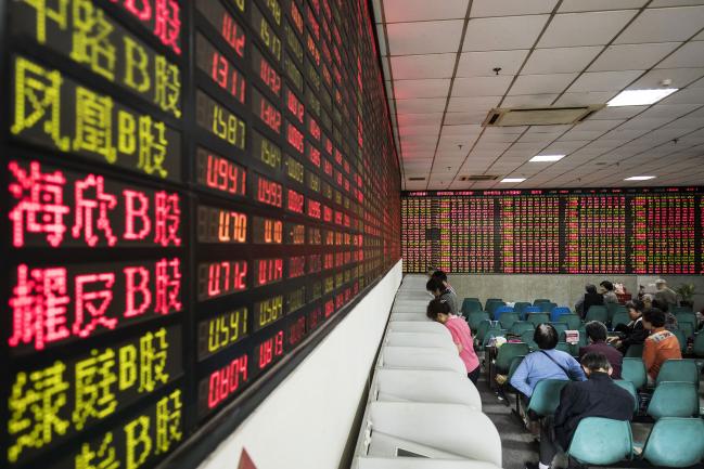 © Bloomberg. Investors stand at trading terminals in front of electronic stock boards at a securities brokerage in Shanghai, China, on Friday, Oct. 13, 2017. A number of economic indicators show \\