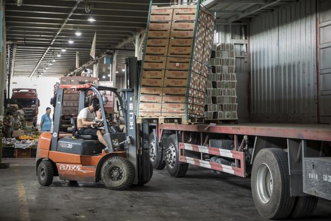 © Bloomberg. A man uses a forklift to unload a pallet of imported fruit from a truck at a wholesale market in Shanghai, China, on Friday, July 13, 2018. China is scheduled to release gross domestic product (GDP) figures on July 16. 