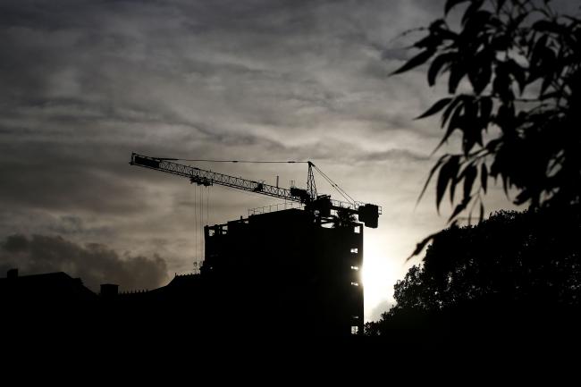 © Bloomberg. A crane is silhouetted as it operates at a residential construction site in the suburb of North Sydney in Sydney, Australia, on Wednesday, June 20, 2018. Australia is riding out a huge gamble on property. The bet: 27 years of recession-free economic growth—during which Sydney home prices surged fivefold—would continue unabated and allow borrowers to keep servicing their debt. Photographer: Lisa Maree Williams/Bloomberg