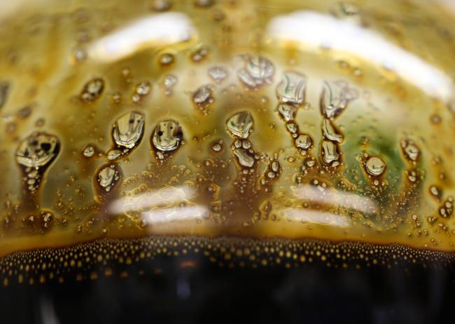 © Bloomberg. A sample of crude oil sits in a glass flask during testing. Photographer: Andrey Rudakov/Bloomberg