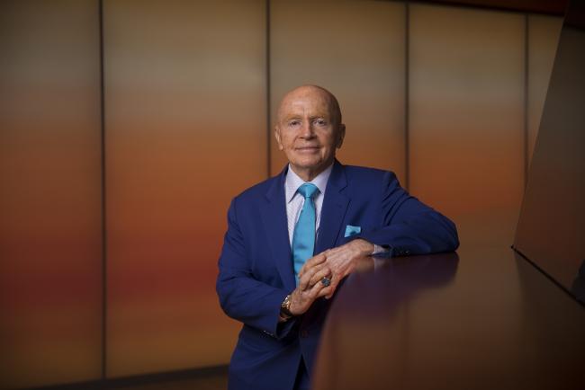 © Bloomberg. Mark Mobius, co-founder of Mobius Capital Partners, poses for a photograph following a Bloomberg Television interview in London, U.K., on Wednesday, May 15, 2019. The emerging-market benchmark index will probably keep falling if the trade war persists, given China's significant weighting, Mobius said during the interview. Photographer: Simon Dawson/Bloomberg