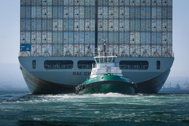© Bloomberg. A tugboat guides the Kawasaki Kisen Kaisha Ltd. Bai Chay Bridge cargo ship into the Port of Long Beach in Long Beach, California, U.S., on Wednesday, April 4, 2018. The U.S. trade deficit widened by more than forecast to a fresh nine-year high in February amid broad-based demand for imports, ahead of Trump administration tariffs that have raised the specter of a trade war. 