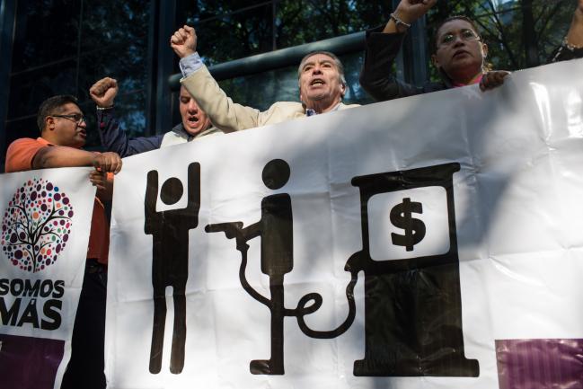 © Bloomberg. Demonstrators protest against the government's gasoline price hike in front of the office for Mexico's Attorney General in Mexico City, Mexico, on Friday, Jan. 6, 2016. In a conference Wednesday, President Enrique Pena Nieto said he understood public outrage over the gas-price hike, but that it was a necessary move to reflect higher global prices. Photographer: Brett Gundlock/Bloomberg via Getty Images
