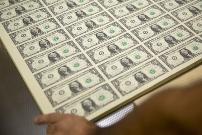 © Bloomberg. Stacks of 2017 50 subject uncut sheets of $1 dollar notes bearing the name of U.S. Treasury Secretary Steven Mnuchin sit in a machine at the U.S. Bureau of Engraving and Printing in Washington, D.C., U.S., on Wednesday, Nov. 15, 2017. A change in the Senate tax-overhaul plan that would expand a temporary income-tax break for partnerships, limited liability companies and other so-called 