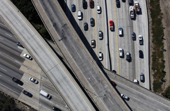© Bloomberg. Vehicles move along the Interstate 405 freeway during rush hour in this aerial photograph taken over the Westwood neighborhood of Los Angeles, California, U.S., on Friday, July 10, 2015. The greater Los Angeles region routinely tops the list for annual traffic statistics of metropolitan areas for such measures as total congestion delays and congestion delays per peak-period traveler.