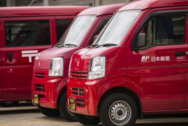 © Bloomberg. Postal vans stand in front of the Seijo Post Office, operated by Japan Post Holdings Co., in Tokyo, Japan, on Monday, Sept. 11, 2017. Japan's government will sell about 1.3 trillion yen ($12 billion) of shares in Japan Post, the latest phase in the privatization of the postal and financial-services giant. 