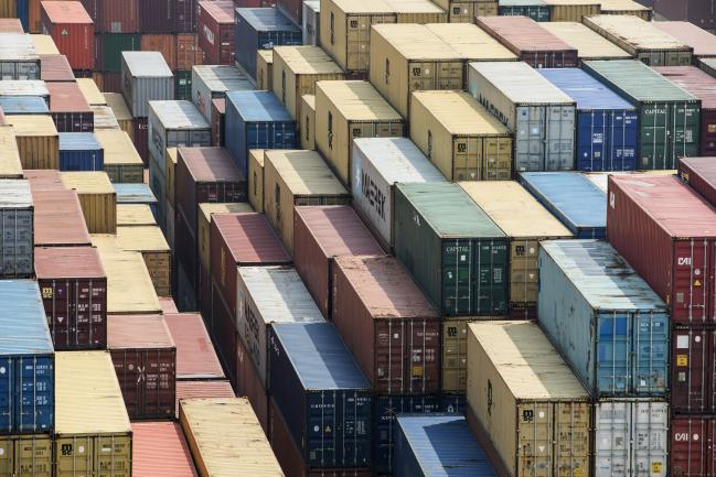 © Bloomberg. Shipping containers stand in a terminal at the Yangshan Deep Water Port in Shanghai, China, on Friday, March 23, 2018. The trade conflict between China and the U.S. escalated, with Beijing announcing its first retaliation against metals levies hours after President Donald Trump outlined fresh tariffs on $50 billion of Chinese imports and pledged there's more on the way. 