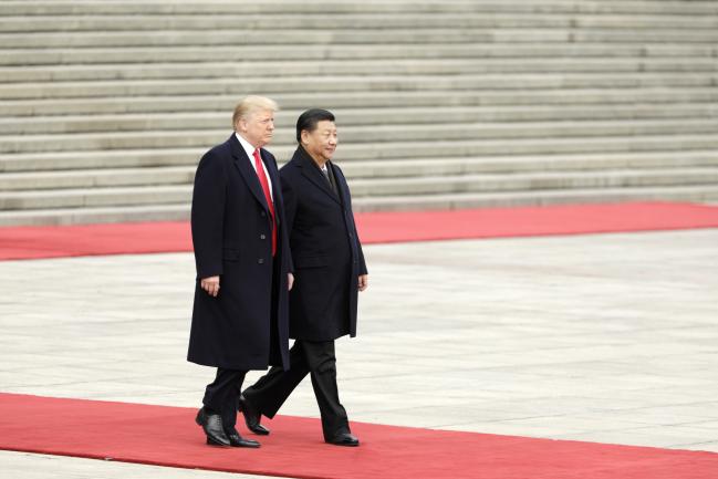 © Bloomberg. U.S. President Donald Trump, left, walks with Xi Jinping, China's president, during a welcome ceremony outside the Great Hall of the People in Beijing, China, on Thursday, Nov. 9, 2017.  Photographer: Qilai Shen/Bloomberg