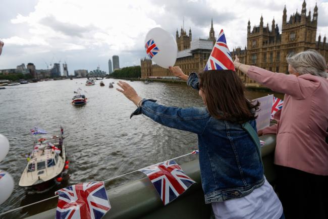 © Bloomberg. A campaigner waves a balloon featuring a British Union Flag, also known as a Union Jack, as boats pass underneath Westminster Bridge near the Houses of Parliament in London, U.K., Wednesday, June 15, 2016. The Brexit battle took to London's River Thames as boats supporting the 