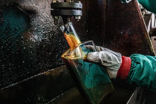 © Bloomberg. An employee collects a sample of light refined diesel fuel for quality control testing at a facility in the Duna oil refinery, operated by MOL Hungarian Oil & Gas Plc, in Szazhalombatta, Hungary. 