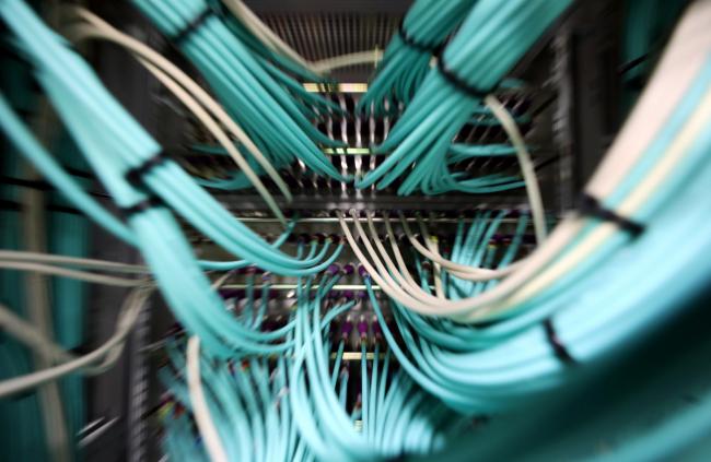 © Bloomberg. Coaxial cables connect to a computer server unit inside a communications room at an office in London, U.K., on Monday, May 15, 2017. Governments and companies around the world began to gain the upper hand against the first wave of an unrivaled global cyberattack, even as the assault was poised to continue claiming victims this week.