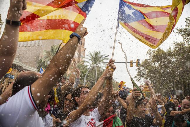 © Bloomberg. Pro-Catalan separatist supporters celebrate following the vote to declare independence from Spain by the Catalan parliament in Barcelona, Spain, on Friday, Oct. 27, 2017. Catalonias tumultuous push for independence is on a knife edge after separatists turned on Puigdemont on Thursday when he was moments away from capitulating to pressure from Spain.