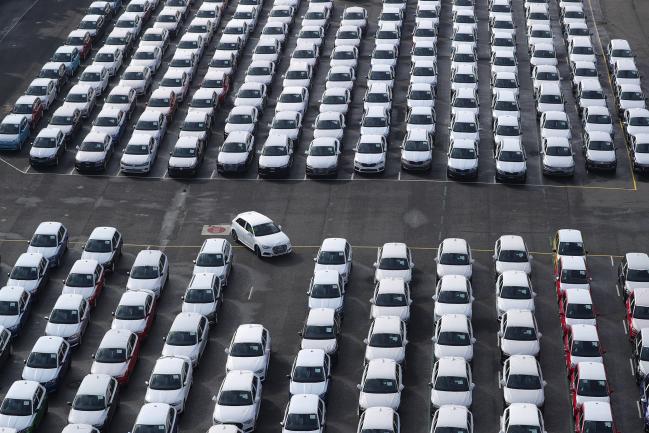© Bloomberg. A newly manufactured Audi AG automobile is driven into a parking space as Volkswagen AG (VW) brand vehicles stand ahead of shipping outside the VW factory at the port in Emden, Germany, on Friday, March 9, 2018. German carmaker VW will spend about 400 million euros ($495 million) to switch power plants at its Wolfsburg headquarters to gas from coal as it moves to slash carbon emissions in production. Photographer: Krisztian Bocsi/Bloomberg