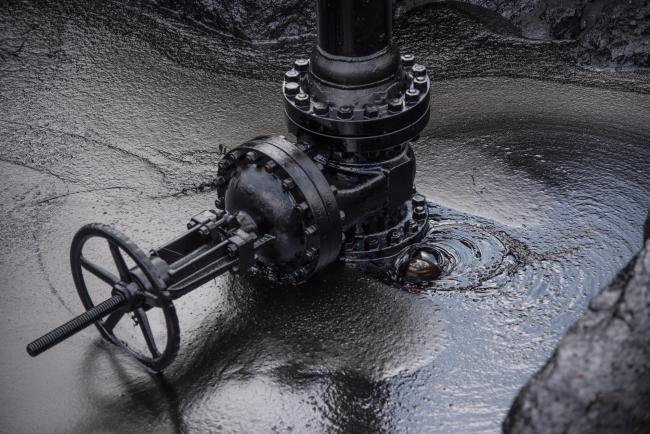 © Bloomberg. A pipe leaks oil at a Petroleos de Venezuela SA (PDVSA) facility in El Tigre, Venezuela, on Sunday, Oct. 14, 2018. State-owned PDVSA doesn't publish statistics, but environmentalists and analysts keep seemingly endless lists of examples of wayward crude - unleashed by busted valves, ripped gaskets, and cracked pipes - that they say has polluted waterways and farmland and probably has seeped into the nation's aquifers. 