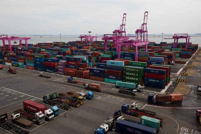 © Bloomberg. Containers sit stacked among gantry cranes at the Sun Kwang Newport Container Terminal (SNCT) in Incheon New Port in Incheon, South Korea, on Monday, Sept. 4, 2017.