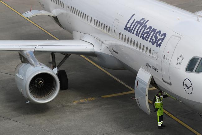 © Bloomberg. A ground crew member stands beneath an Airbus A321 aircraft, operated by Deutsche Lufthansa AG, at Tegel airport in Berlin, Germany, on Wednesday, March 13, 2019. Boeing Co. staggered into a deepening global crisis as governments around the world grounded the company's best-selling jet over safety concerns after a second deadly crash. Photographer: Krisztian Bocsi/Bloomberg