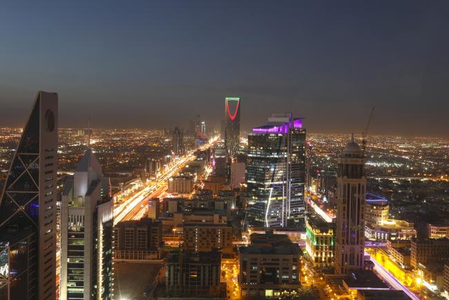 © Bloomberg. Light trails from automobile traffic traveling along the King Fahd highway, left, and Olaya Street, right, lead towards the Kingdom Tower, center rear, in Riyadh, Saudi Arabia, on Thursday, Dec. 1, 2016. Photographer: Simon Dawson/Bloomberg