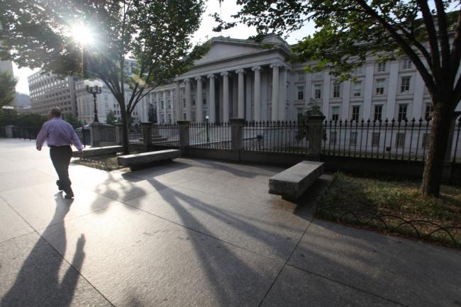 © Bloomberg. A pedestrian passes in front of the closed U.S. Treasury building in Washington D.C., U.S.