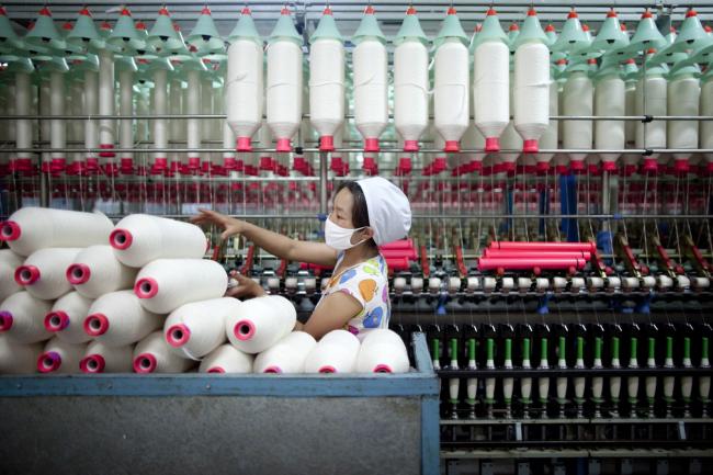 © Bloomberg. A worker manufactures cotton yarn at a factory in Dali county, Shaanxi province, China, on Wednesday, April 27, 2011. China, the largest cotton importer, cancelled orders for more than 100,000 bales in April after heavy buying in March, according to the U.S. Department of Agriculture. Photographer: Nelson Ching/Bloomberg 