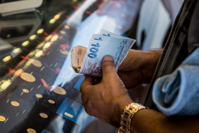 © Bloomberg. A customer changes dollars into Turkish lira at a foreign currency exchange store in Istanbul, Turkey, on Thursday, Aug. 16, 2018. Turkish Treasury and Finance Minister Berat Albayrak ruled out restrictions on movement of capital as a policy option, seeking to bolster confidence during a conference call on Thursday. Photographer: Nicole Tung/Bloomberg