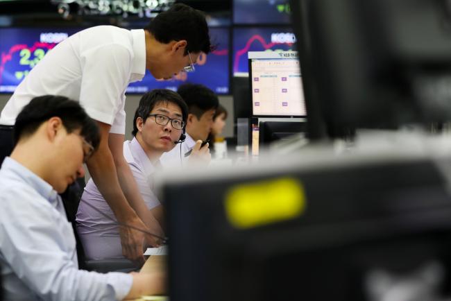 © Bloomberg. Foreign currency dealers talk in a dealing room of KEB Hana Bank in Seoul, South Korea, on Monday, Sept. 4, 2017. Asian stocks fell as investors turned to haven assets after the dictatorship tested a nuclear bomb on Sunday, sending the yen, gold and Treasury futures higher. Photographer: SeongJoon Cho/Bloomberg