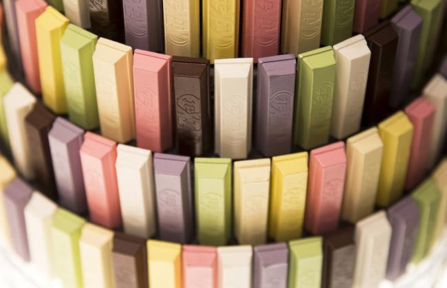© Bloomberg. KitKat bars in a variety of flavors and colors are displayed at the KitKat Chocolatory Ginza store, operated by Nestle SA, during a media preview in Tokyo, Japan, on Monday, July 24, 2017. Recent offerings in KitKat flavors from custard pudding to ginger have made Japan the go-to destination for picking up odd variations. They're so popular among tourists that Nestle is building its first KitKat factory in 26 years to meet booming demand. Photographer: Tomohiro Ohsumi/Bloomberg