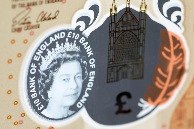 © Bloomberg. A transparent window featuring a portrait of Queen Elizabeth II sits next to a finely detailed metallic image of Winchester Cathedral and a colored quill which changes from orange to purple when tilted on the new U.K. 10-pound banknote in this arranged photograph taken at the Bank of England in the City of London, U.K., on Monday, Sept. 11, 2017. The new bills, which replace the image of naturalist Charles Darwin with that of early-19th century novelist Jane Austen, will be issued on Sept. 14 and will be the first to include a tactile feature to help the visually impaired.
