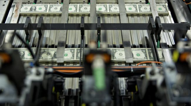 © Bloomberg. Stacks of $1 dollar notes bearing the name of U.S. Treasury Secretary Steven Mnuchin move through a machine at the U.S. Bureau of Engraving and Printing in Washington, D.C., U.S., on Wednesday, Nov. 15, 2017. A change in the Senate tax-overhaul plan that would expand a temporary income-tax break for partnerships, limited liability companies and other so-called 