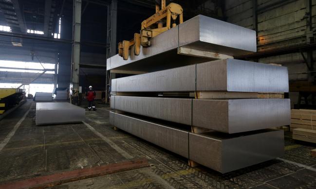 © Bloomberg. A worker watches as large aluminum slabs are moved by overhead crane in the foundry at the Krasnoyarsk aluminum smelter, operated by United Co. Rusal, in Krasnoyarsk, Russia. 