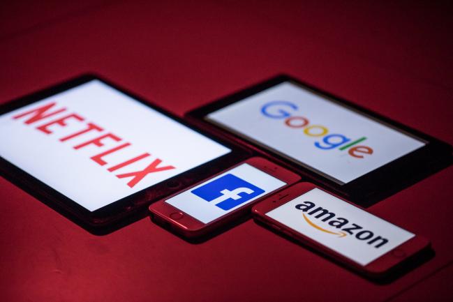 © Bloomberg. The logos for Facebook Inc., Amazon.com Inc., Netflix Inc. and Google, a unit of Alphabet Inc., sit on smartphone and tablet devices in this arranged photograph in London, U.K., on Monday, Aug. 20, 2018. The NYSE FANG+ Index is an equal-dollar weighted index designed to represent a segment of the technology and consumer discretionary sectors consisting of highly-traded growth stocks of technology and tech-enabled companies. Photographer: Jason Alden/Bloomberg