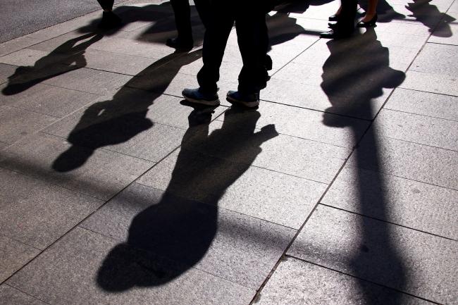 © Bloomberg. Pedestrians cast shadows on the ground as they walk in the central business district of Sydney, Australia, on Wednesday, May 15, 2019. Australia's economy has been weighed down by a retrenchment in household spending as property prices slump and slash personal wealth. An election Saturday is likely to see the opposition Labor party win power and lift spending further. 